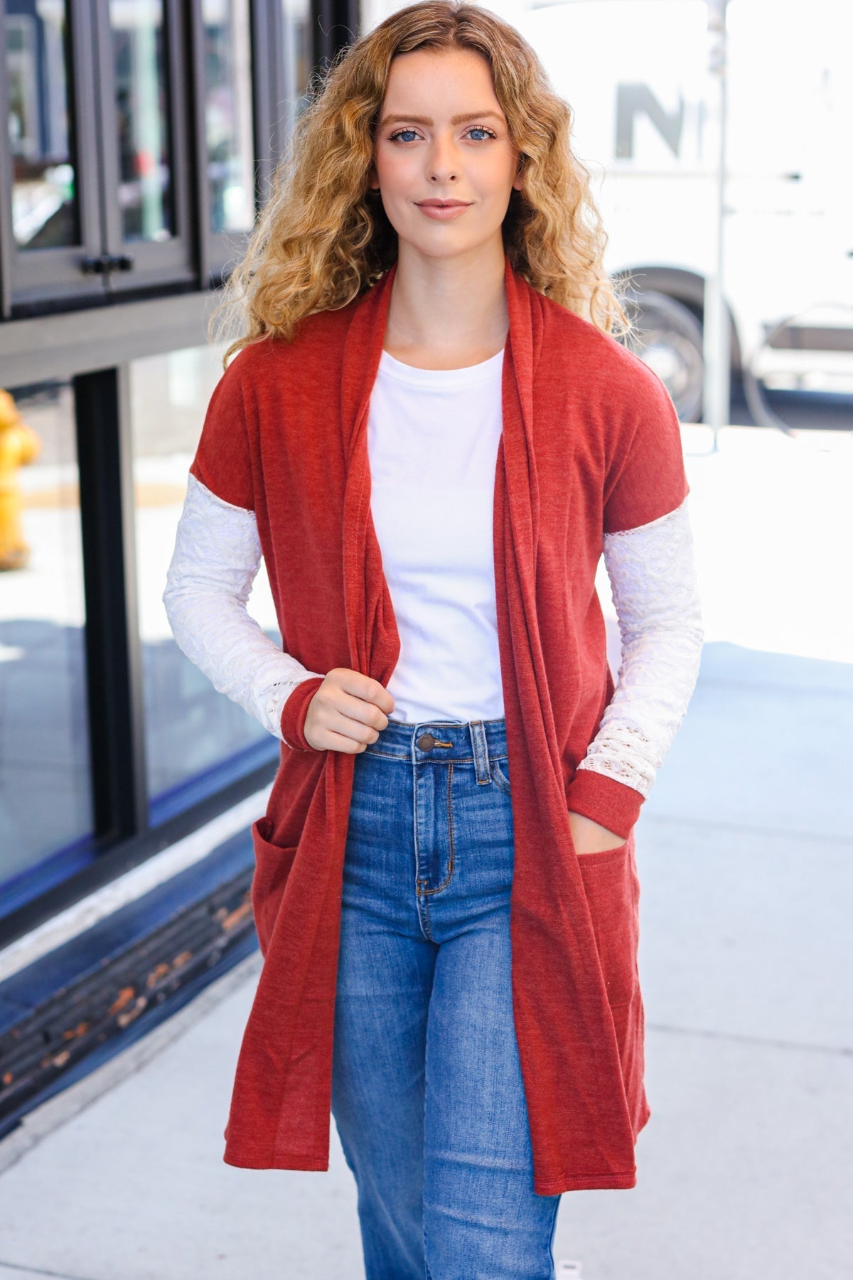 Women standing on a sidewalk wearing a cardigan